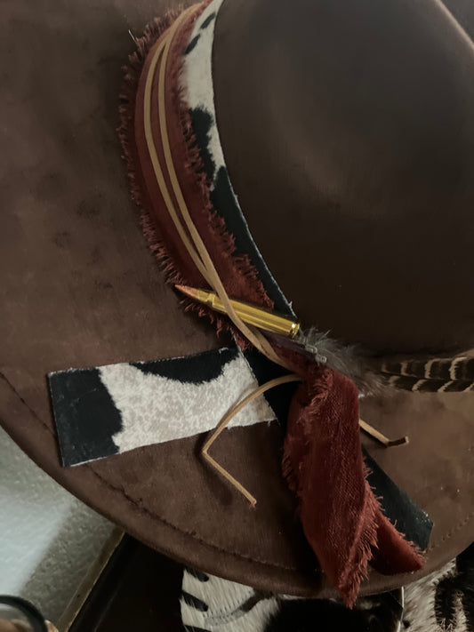 Brown  vegan suede rancher cowboy hat with cowhide band with velvet trim, beautiful bold feathers a small pistol charm and bullet accent