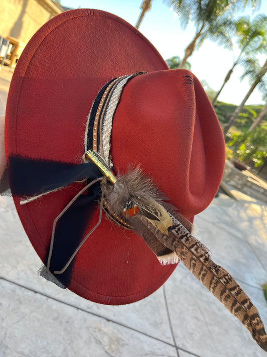 Burnt orange distressed Fedora Hat with Handcrafted black tan and leather band with gold studs feathers cased in a we the people bullet
